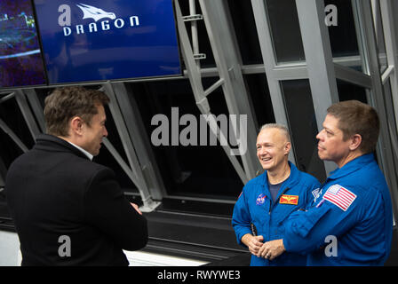 SpaceX CEO e Chief Designer Elon Musk, sinistra, parla con gli astronauti della NASA Doug Hurley, centro e Bob Behnken, a destra dalla camera di cottura 4 del lancio di centro di controllo presso il Kennedy Space Center Il 2 marzo 2019 a Cape Canaveral, in Florida. Il test di lancio della SpaceX equipaggio commerciale Demo di capsula-1, sollevata permettendo con successo gli astronauti nella demo presidiata-2 missione di procedere. Foto Stock