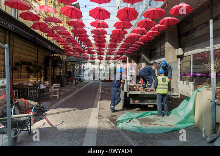 Belgrado, Serbia, Marzo 2019 - Costruzione dei lavoratori sul posto di lavoro in red ombrelloni sospesi al di sopra della cara Lazara strada pedonale in zona della città Foto Stock