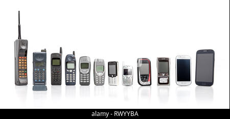 Vecchio telefono cellulare dal passato al presente su sfondo bianco. Foto Stock