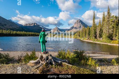 Giovane donna che guarda al lago di montagna Medicina due lago nel paesaggio di montagna, back Sinopah Mountain, il Glacier National Park Foto Stock