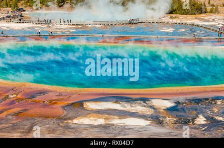 I turisti su un molo nella zona termale, fumanti sorgenti calde, Grand Prismatic Spring, Midway Geyser Basin Foto Stock