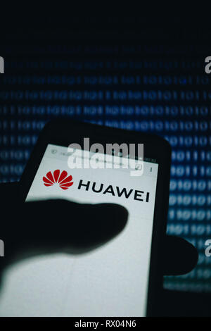 Huawei logo sul suo sito web è mostrato su un display dello smartphone, numeri bianchi zero, un codice binario come una texture, gradiente blu non focalizzato sullo sfondo Foto Stock