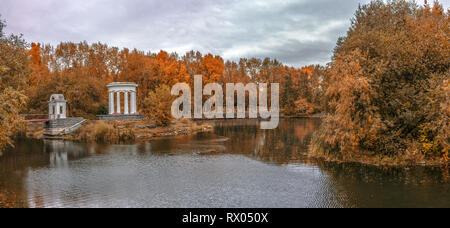 Stagno in un verde parco cittadino con una rotonda nel tardo autunno dorato Foto Stock