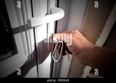 Stretta di mano utilizzando la chiave per aprire la porta di nuovo di zecca appena acquistato,casa. Doppi vetri,anteriore,porta,UPVC,Cowes, Isle of Wight, England, Regno Unito Foto Stock