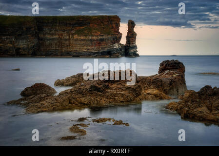 Freswick Bay scogliere a testa Duncanby nella luce del tramonto, nel nord della Scozia Foto Stock