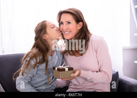 Ritratto di una ragazza dando dono alla sua madre felice Foto Stock