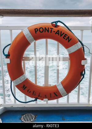 Anello vita Lifebuoy attaccato alle ringhiere, traghetto Pont-Aven Bretagna. Vista attraverso il centro dell'orizzonte e sveglia di traghetto, mare, vela English Channel, EU Foto Stock