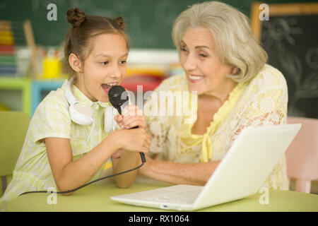 Ritratto della nonna e la figlia di cantare il karaoke Foto Stock