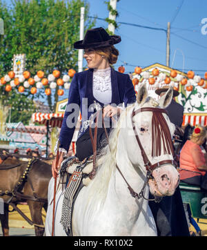 Giovane e bella donna attraente cavalcare cavalli andalusi (puro Cavallo Spagnolo) e la celebrazione di Siviglia fiera di aprile Foto Stock