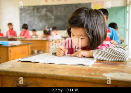 Elementare scuola di età i bambini che frequentano la classe in una classe rurale nella regione di Guangxi del centro sud della Cina. Foto Stock