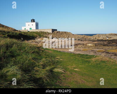 Faro sulla riva a Bamburgh, Northumberland, Inghilterra, erbaceo con dune di sabbia Foto Stock