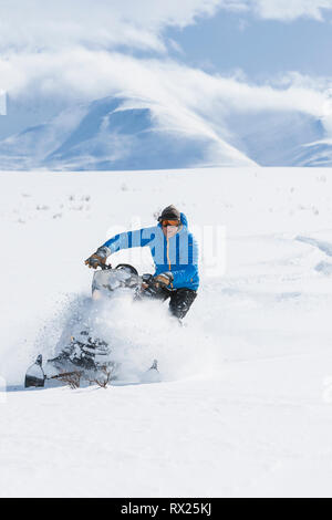 Un snowmobiler scolpisce attraverso soffice polvere secca a nord Canol sentiero vicino a MacMillan Pass. Yukon Territory, Canada. Foto Stock