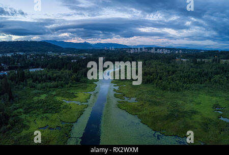 Antenna vista panoramica del lago di Burnaby durante una drammatica NUVOLOSO TRAMONTO D'estate. Preso in Vancouver, British Columbia, Canada. Foto Stock