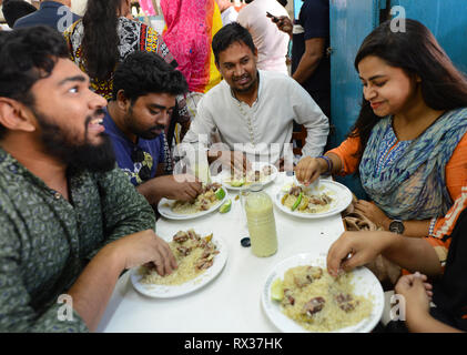 Moda giovane Bangladeshis godendo il loro Biriyani all'Originale Haji Biryani nella vecchia Dhaka. Foto Stock