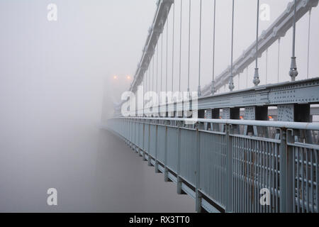 Menai Bridge sospensione scompare attraverso la foschia sopra di Anglesey nel Galles del Nord Foto Stock