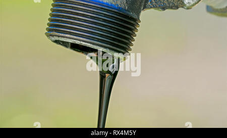 Un nero fluido che fuoriesce dal rubinetto. È come un olio di colore nero proveniente da un tubo Foto Stock