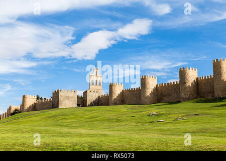 Vista delle mura medievali che circondano la città di Avila, Spagna e il prato verde di fronte a Puerta del Carmen. Chiamato la città di pietre e Foto Stock