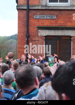 Ashbourne Shrovetide Football 2019. Le mani in un mare di giocatori afferrare per la palla su St John Street come giocare entra in città durante il Mercoledì delle Ceneri gioco. Foto Stock