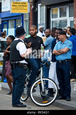 La polizia offre a parlare con la gente locale durante un vasto nella comunità giorno su un High Street nel nord ovest di Londra. Il 2 giugno 2014. Foto Stock