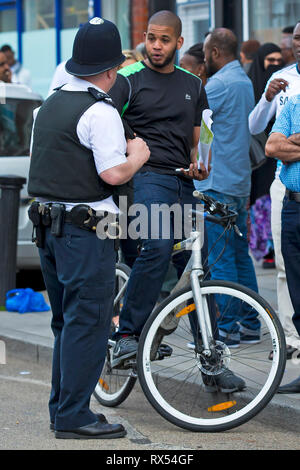 La polizia offre a parlare con la gente locale durante un vasto nella comunità giorno su un High Street nel nord ovest di Londra. Il 2 giugno 2014. Foto Stock