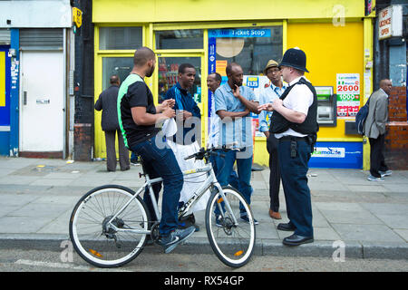 La polizia offre a parlare con la gente locale durante un vasto nella comunità giorno su un High Street nel nord ovest di Londra. Il 2 giugno 2014. Foto Stock