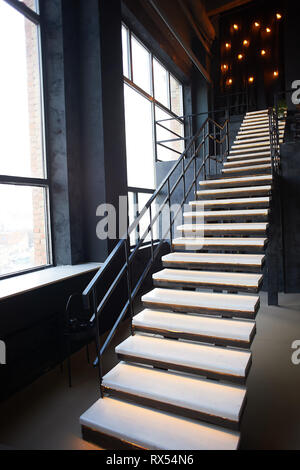 Nero ad alta scala di metallo con gradini in legno in stile loft camera Foto Stock
