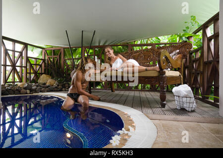 Giovane a bordo piscina del resort Foto Stock