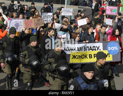 Kiev Kiev, Ucraina. 8 Mar, 2019. Ukrainian poliziotti e guardie nazionali sono visto che accompagnano i manifestanti tenendo striscioni e cartelli e bandiere durante la dimostrazione.le femministe ucraine e i loro sostenitori hanno tenuto il loro marzo impegnativo per i diritti delle donne in tutto il mondo e contro la violenza domestica durante la giornata internazionale della donna che si celebra ogni anno il 8 marzo. Credito: Pavlo Gonchar SOPA/images/ZUMA filo/Alamy Live News Foto Stock