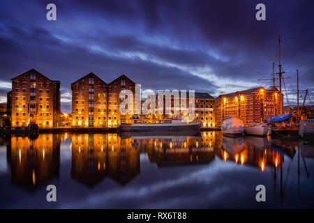Gloucester docks di notte con la riflessione dei magazzini e delle barche sul canale della nitidezza Foto Stock