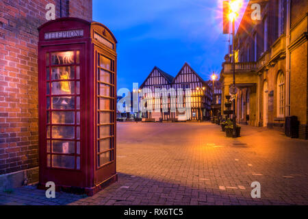 Nella casella Telefono in Evesham comune con il vecchio edificio in background Foto Stock