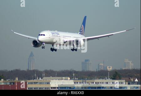 Un Boeing 787 Dreamliner della US-American Airline Regno, atterraggio sulla pista nord-ovest dell'aeroporto di Francoforte Rhein-Main. Di seguito: Edificio del Kelsterbach Süd industrial estate. In background: grattacieli della città di Francoforte. | Utilizzo di tutto il mondo Foto Stock