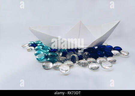 Concettuale e immagine creativa del libro bianco in barca a vela in mare abstarct fatta di marmi colorati Foto Stock
