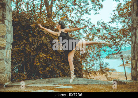 Giovane donna dancing in un giardino Foto Stock