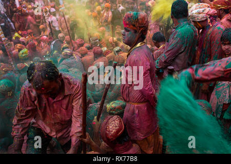 Durante Holi festival, emissari gruppo canta nel centro del tempio mentre altri potrebbe gettare polvere colorata e acqua Foto Stock