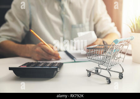 Costo della vita concetto - uomo calcolare le bollette di casa spese quotidiane Foto Stock