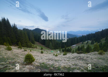 Paesaggio di sera in montagna. Camping i viaggiatori con le tende nel prato Foto Stock