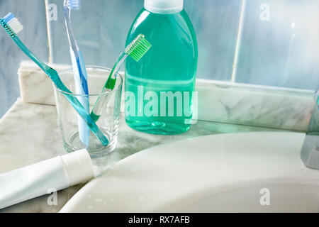 Gli spazzolini da denti e dentifricio e su un lavello. Composizione orizzontale. Vista in elevazione. Foto Stock