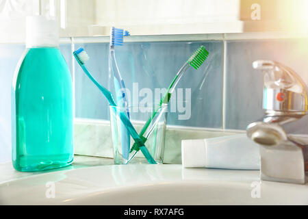 Gli spazzolini da denti e dentifricio e su un lavello. Composizione orizzontale. Vista frontale. Foto Stock