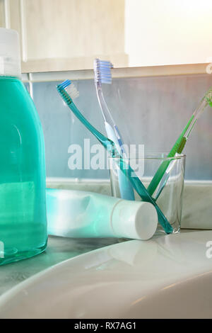 Gli spazzolini da denti e dentifricio e su un lavello. Composizione verticale. Vista frontale. Foto Stock