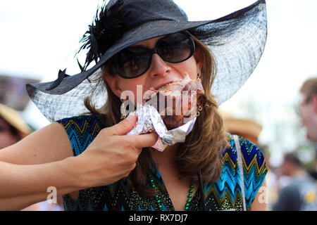 Kentucky Derby corsa di cavalli a Louisville, Stati Uniti d'America - una donna in un fantastico hat aroasted mangia tacchino - Funny Pic Foto Stock