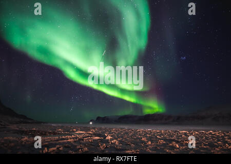 Aurora Boreale vista dalla piccola città artica di Pangnirtung oltre la congelati Cumberland Sound. Foto Stock