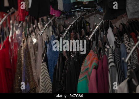 Vestiti su appendiabiti in negozio per la vendita. Foto Stock