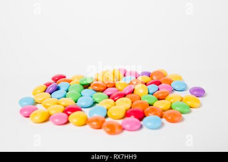 Pila di coloratissimi dolci caramelle, vista laterale - sfondo bianco. Foto Stock