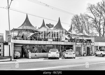 PARYS, SUD AFRICA, 2 agosto 2018: una scena di strada con ristorante, altri negozi e veicoli, in Parys nel libero Stato Provincia. Monocromatico Foto Stock