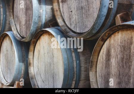 I barili di legno sovrapposti in una pila con vini pregiati presso un vigneto Foto Stock