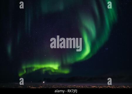 Aurora Boreale vista dalla piccola città artica di Pangnirtung oltre la congelati Cumberland Sound. Foto Stock