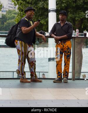Due uomini neri in piedi accanto al Fiume Tamigi in Africa Utopia Festival il London Southbank Foto Stock