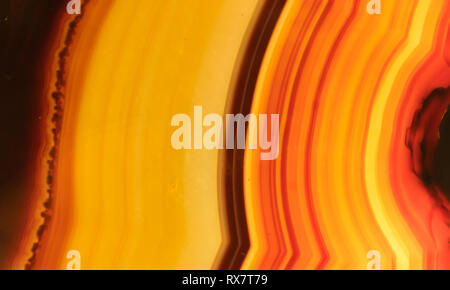 Lucidati onyx pietra minerale con arancione, giallo, marrone e strisce rosse Foto Stock