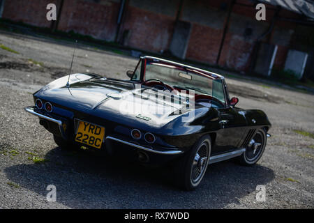 1966 Chevrolet Corvette Stingray convertible parcheggiata vicino ad un vecchio funziona Foto Stock