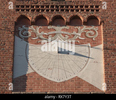 Meridiana sulla facciata in mattoni di un antica chiesa segna 16.30 Foto Stock